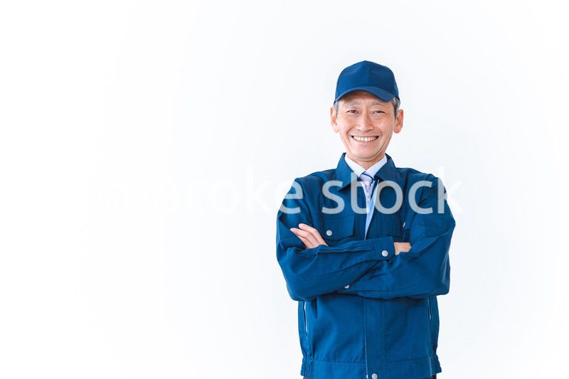 腕を組み笑顔を見せる配達員