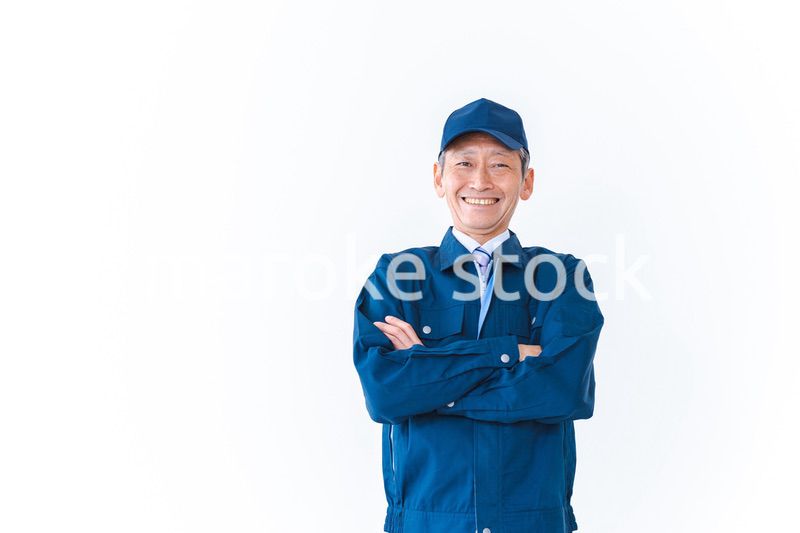 腕を組み笑顔を見せる配達員