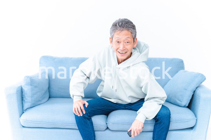 自宅のテレビでスポーツ観戦をする高齢の男性