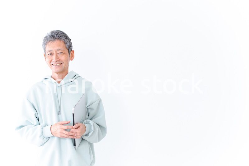 ノートパソコンを持つ高齢の男性