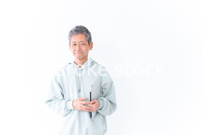 ノートパソコンを持つ高齢の男性