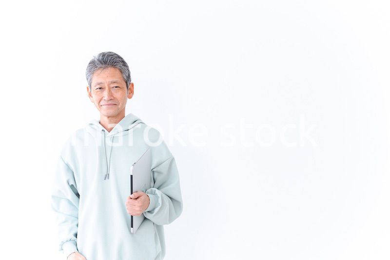 ノートパソコンを持つ高齢の男性