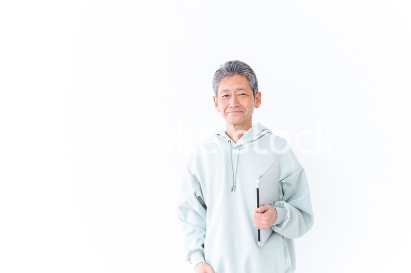 ノートパソコンを持つ高齢の男性