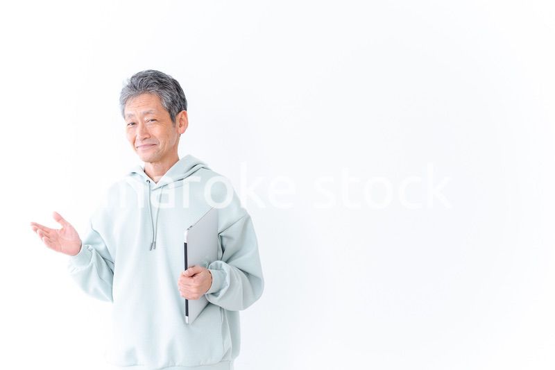 ノートパソコンを持つ高齢の男性