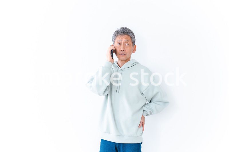 スマホで電話をかける高齢の男性