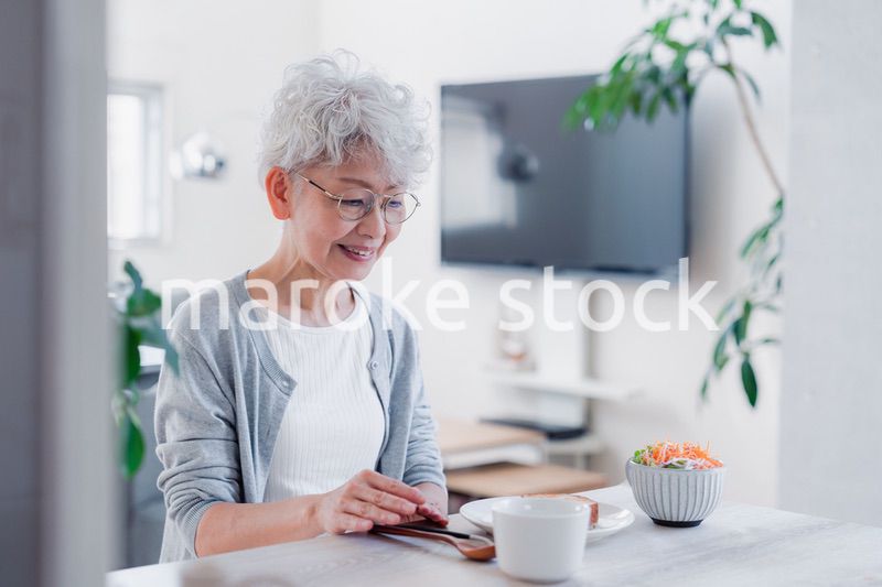 笑顔で朝食を食べるシニアの女性