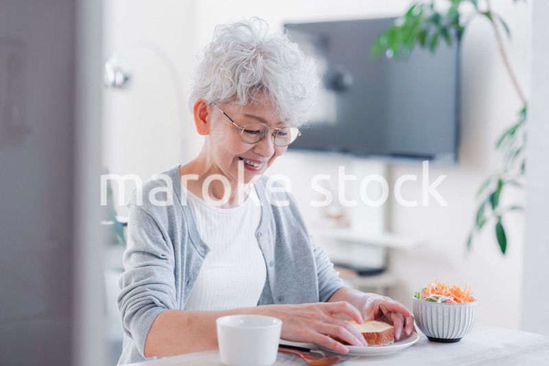 笑顔で朝食を食べるシニアの女性