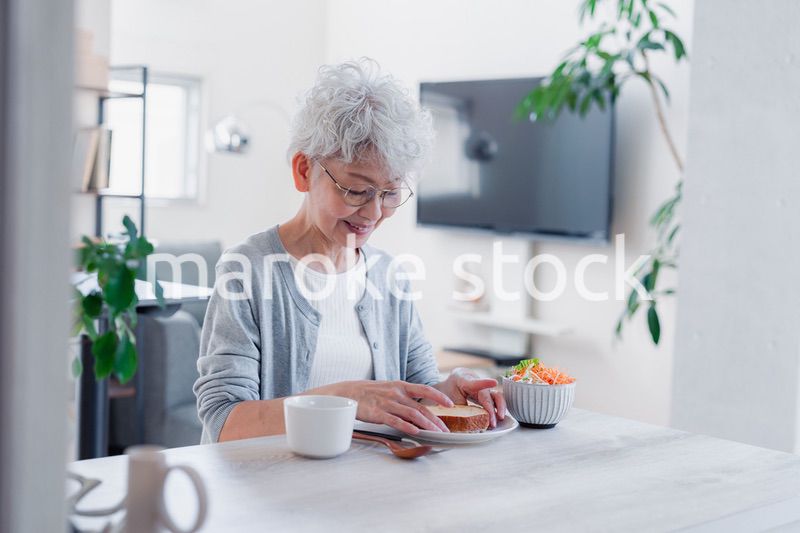 笑顔で朝食を食べるシニアの女性