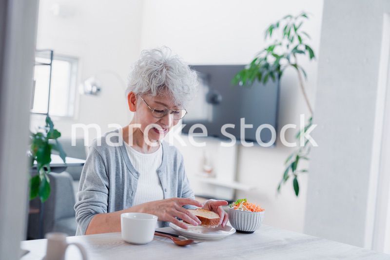 笑顔で朝食を食べるシニアの女性