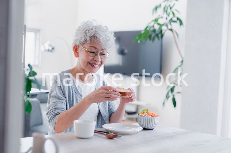 笑顔で朝食を食べるシニアの女性
