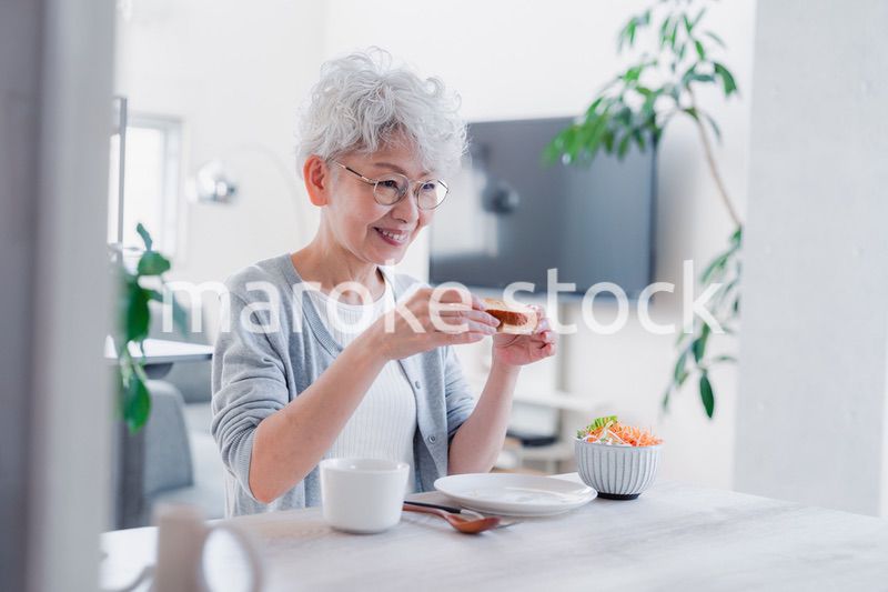 笑顔で朝食を食べるシニアの女性