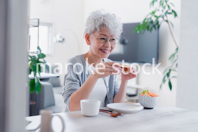 笑顔で朝食を食べるシニアの女性