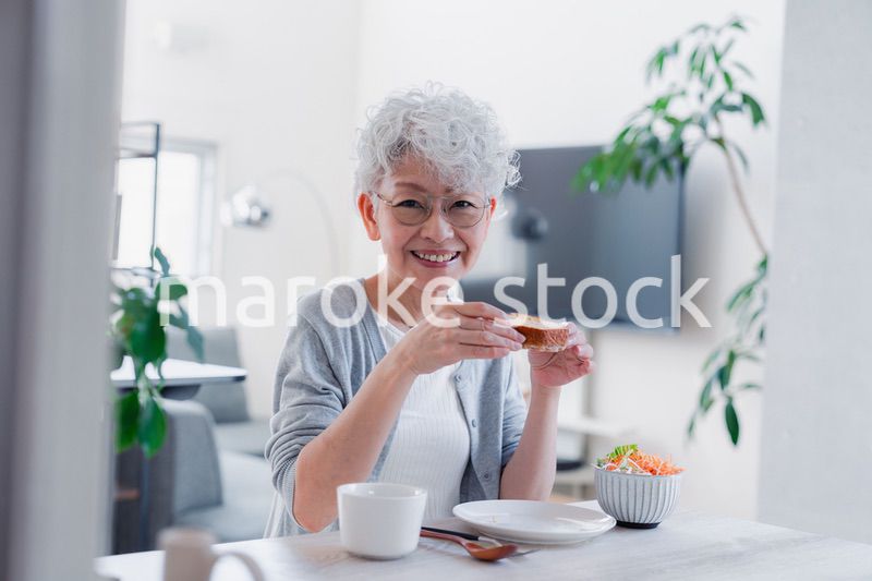 笑顔で朝食を食べるシニアの女性