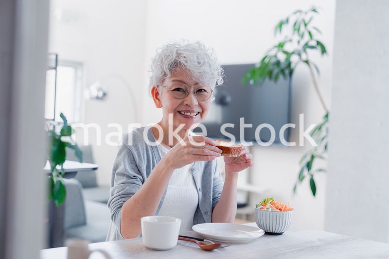 笑顔で朝食を食べるシニアの女性