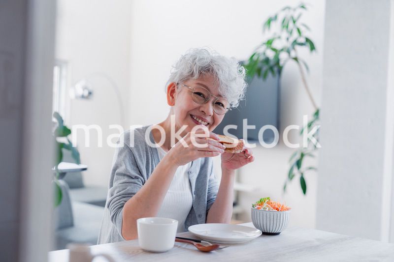 笑顔で朝食を食べるシニアの女性