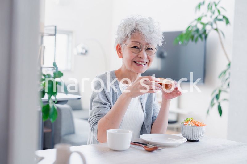 笑顔で朝食を食べるシニアの女性