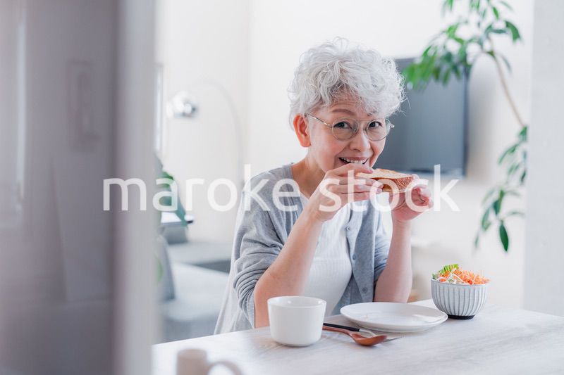 笑顔で朝食を食べるシニアの女性