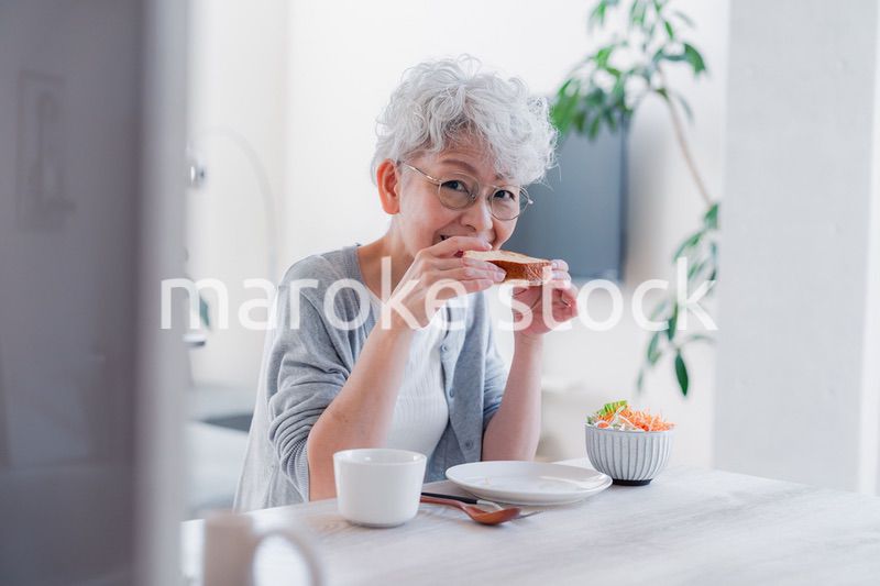 笑顔で朝食を食べるシニアの女性