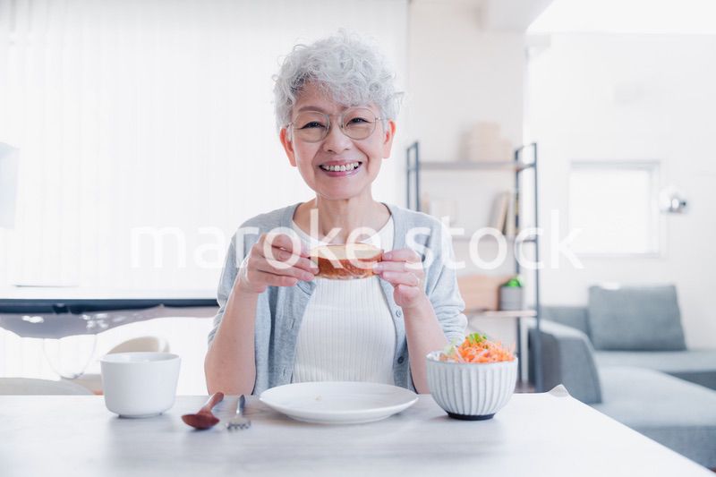 笑顔で朝食を食べるシニアの女性