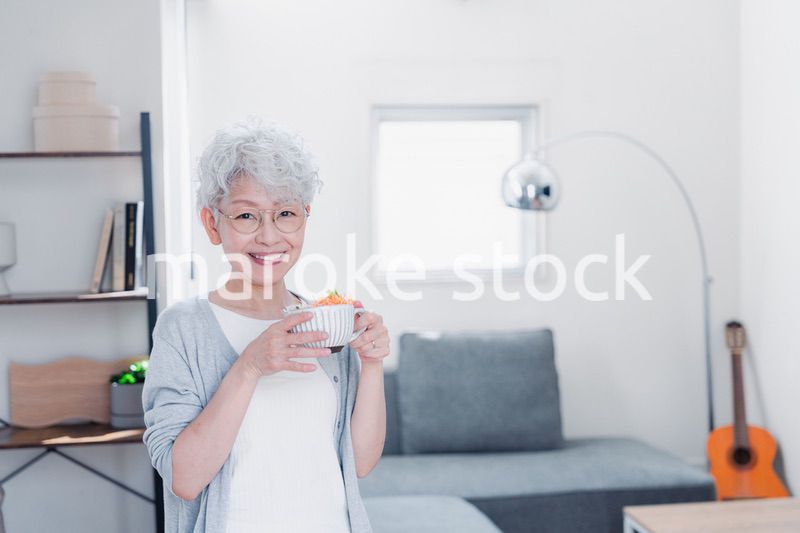 笑顔で朝食を食べるシニアの女性
