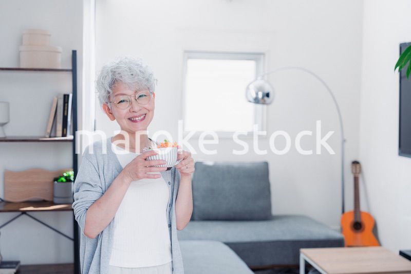 笑顔で朝食を食べるシニアの女性