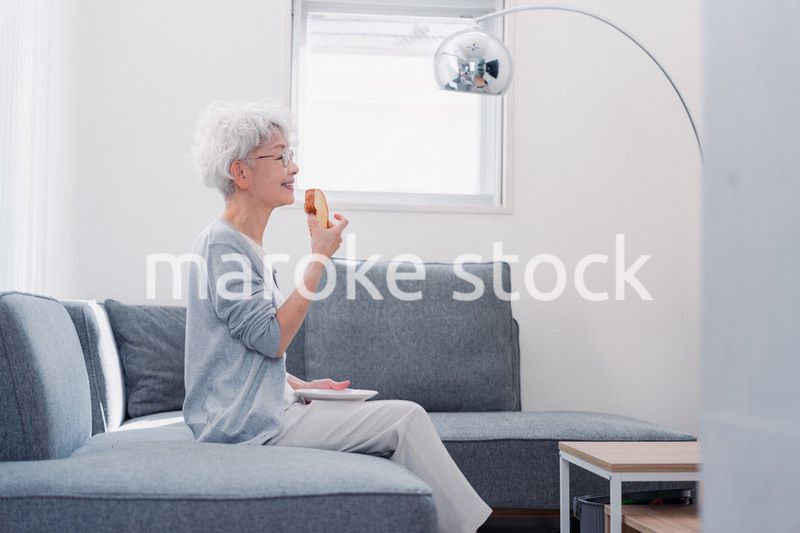 食パンを食べるシニアの女性