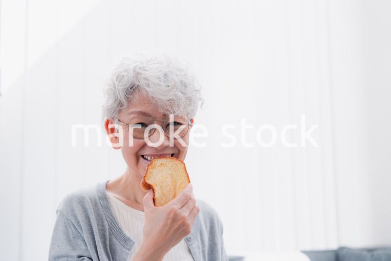 食パンを食べるシニアの女性