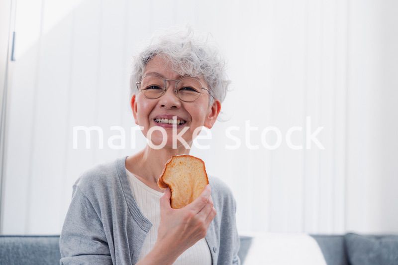食パンを食べるシニアの女性