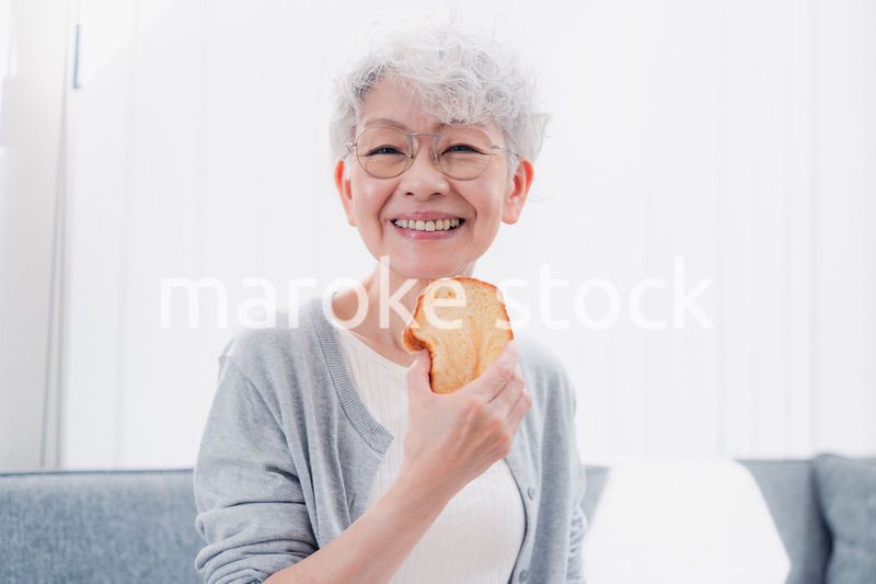 食パンを食べるシニアの女性
