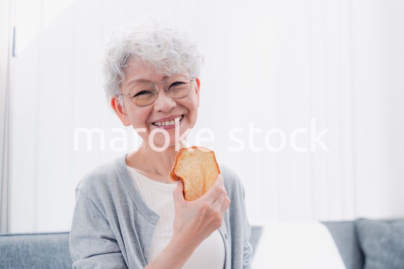 食パンを食べるシニアの女性