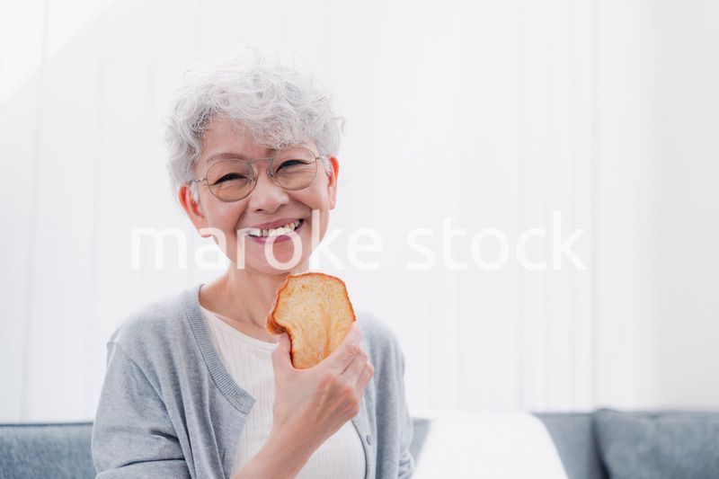 食パンを食べるシニアの女性