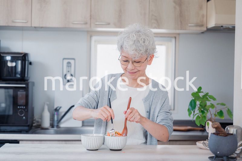 生き生きとご飯を作るシニアの女性