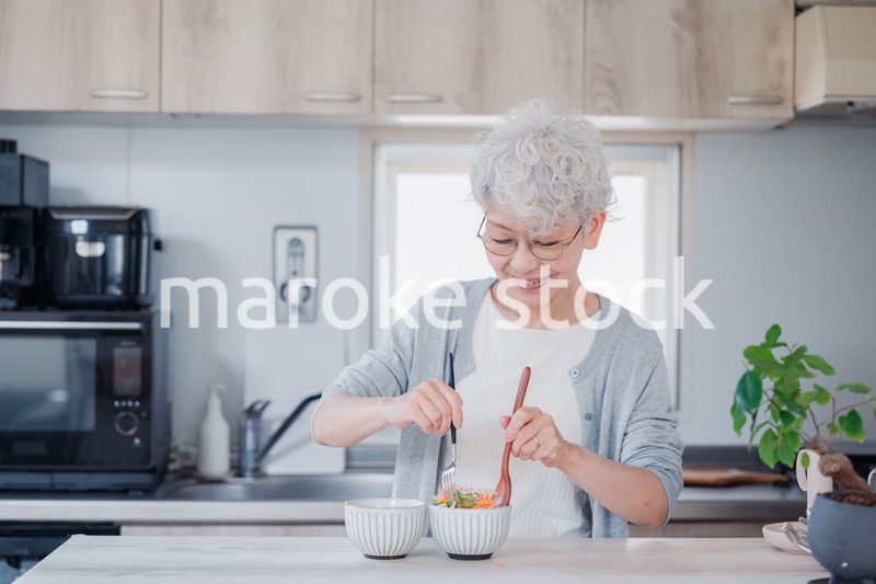 生き生きとご飯を作るシニアの女性