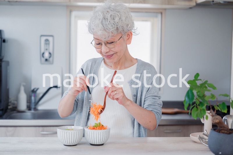 生き生きとご飯を作るシニアの女性