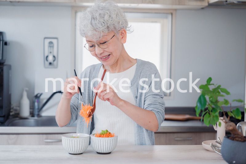 生き生きとご飯を作るシニアの女性