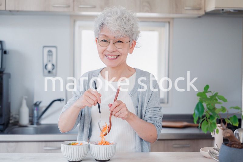 生き生きとご飯を作るシニアの女性