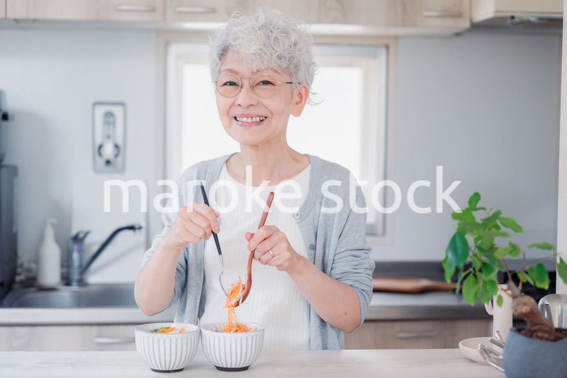 生き生きとご飯を作るシニアの女性