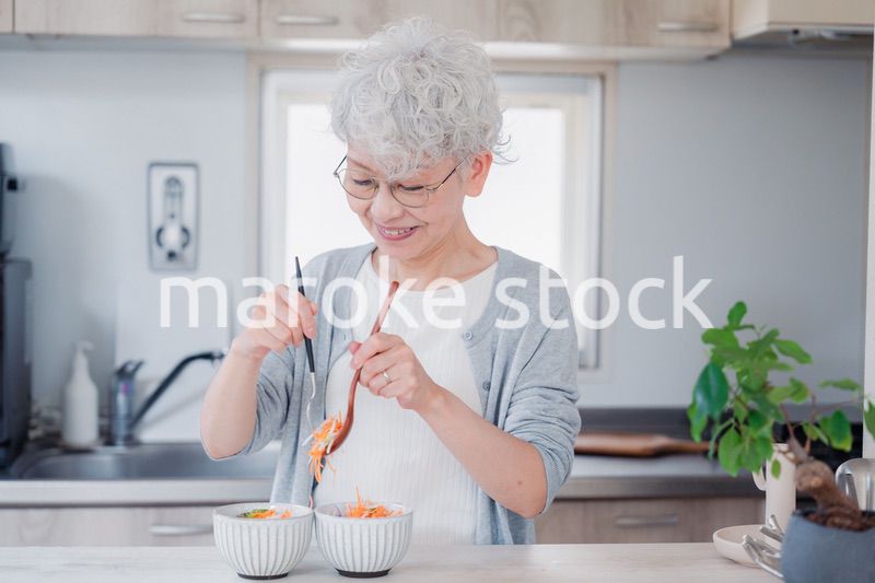 生き生きとご飯を作るシニアの女性