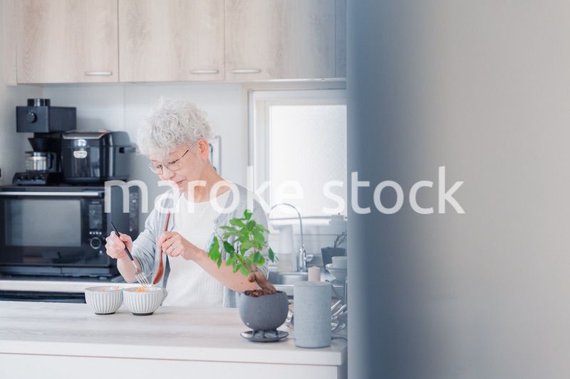 生き生きとご飯を作るシニアの女性