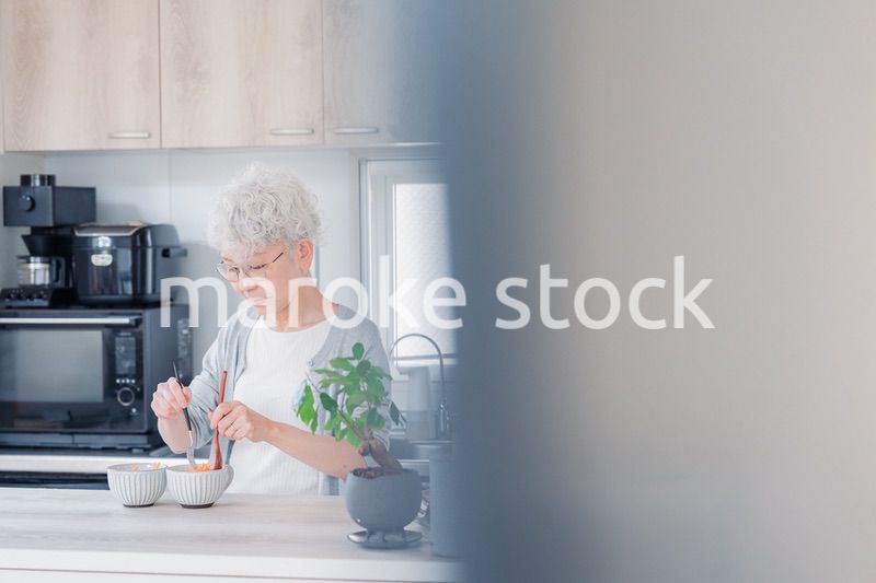 生き生きとご飯を作るシニアの女性