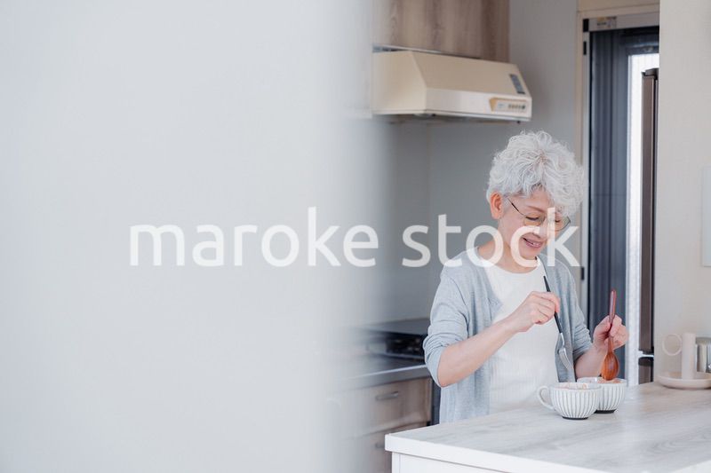 生き生きとご飯を作るシニアの女性