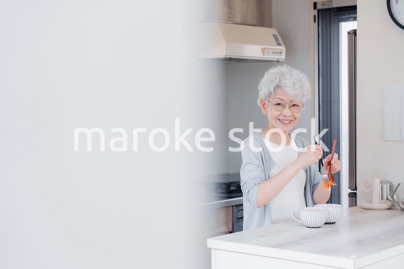 生き生きとご飯を作るシニアの女性