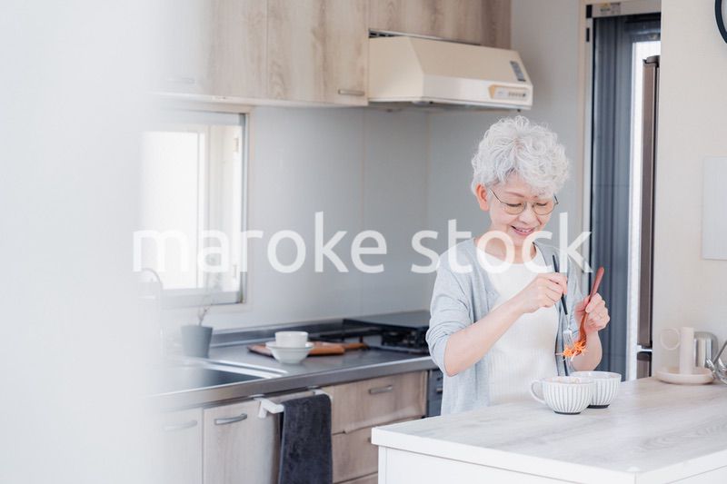 生き生きとご飯を作るシニアの女性