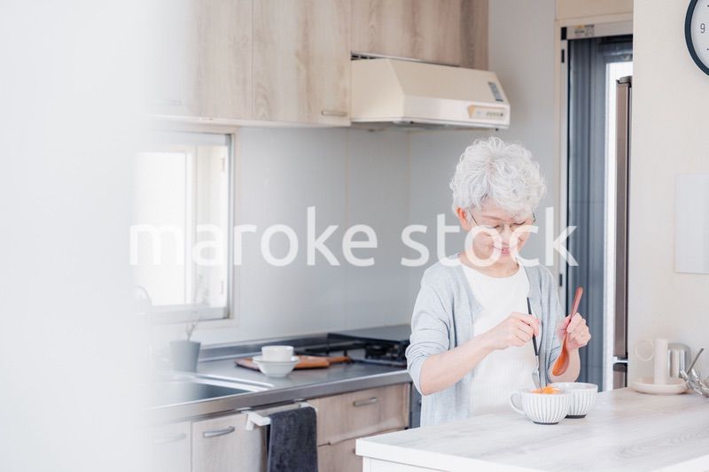 生き生きとご飯を作るシニアの女性