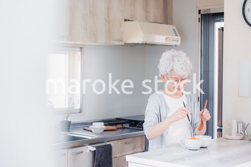 生き生きとご飯を作るシニアの女性