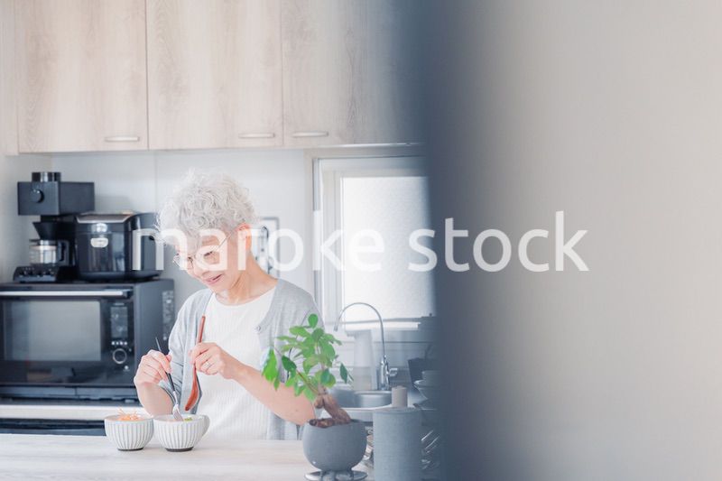 生き生きとご飯を作るシニアの女性