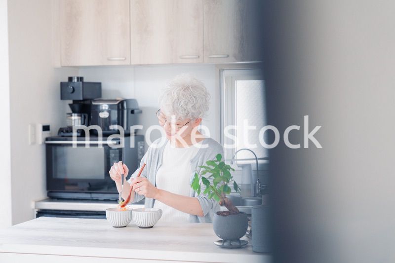 生き生きとご飯を作るシニアの女性