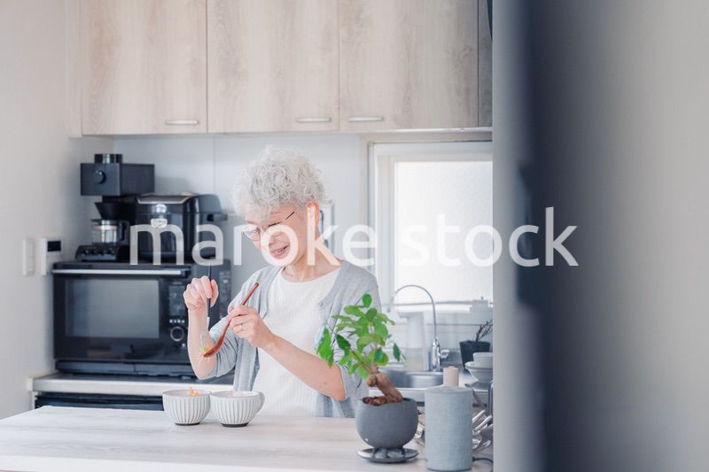 生き生きとご飯を作るシニアの女性