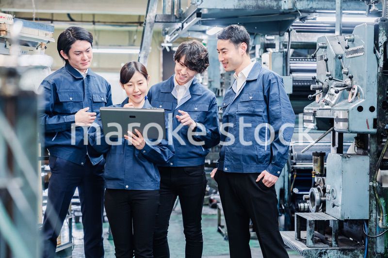 タブレット端末を見ながら会議をする工場スタッフ