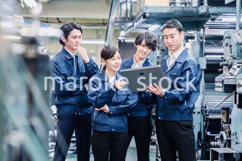 タブレット端末を見ながら会議をする工場スタッフ